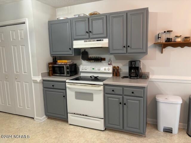 kitchen with a textured ceiling, white range with electric cooktop, and gray cabinets