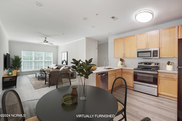 kitchen featuring backsplash, stainless steel appliances, ceiling fan, light brown cabinets, and light hardwood / wood-style floors