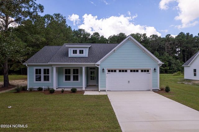 view of front of house featuring a garage, covered porch, and a front lawn