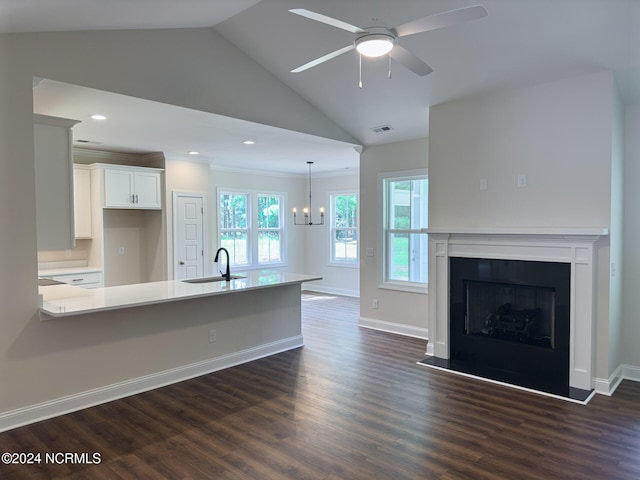 kitchen with dark hardwood / wood-style floors, sink, vaulted ceiling, pendant lighting, and white cabinets