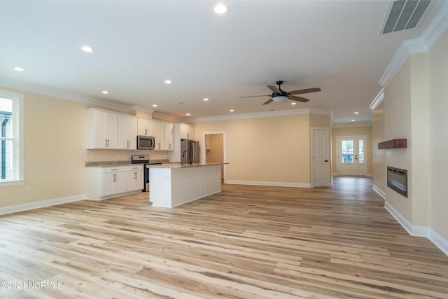 kitchen featuring appliances with stainless steel finishes, open floor plan, white cabinets, and visible vents