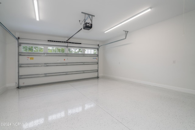 garage with a garage door opener and baseboards