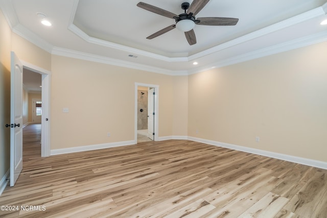 unfurnished room with ornamental molding, a raised ceiling, light wood-style flooring, and baseboards