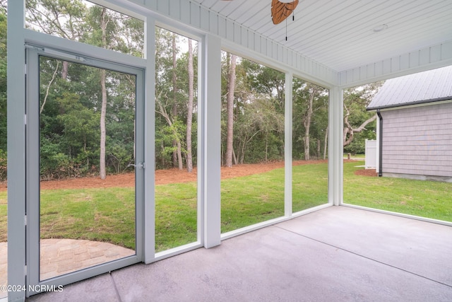 unfurnished sunroom with a ceiling fan and a wealth of natural light