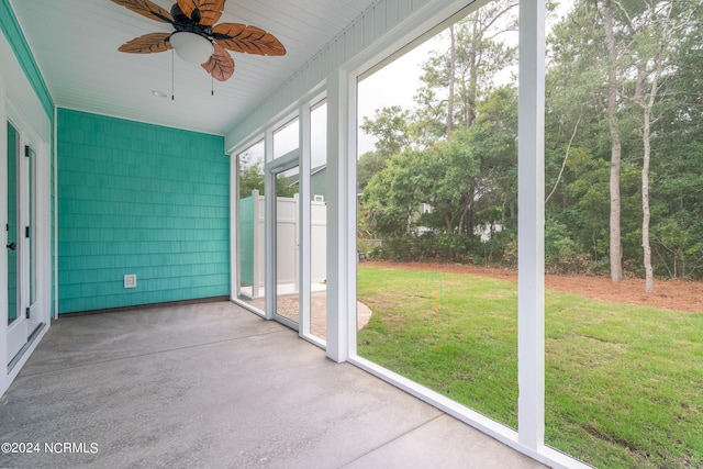 unfurnished sunroom featuring a ceiling fan