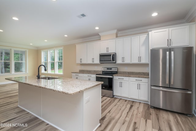 kitchen with stainless steel appliances, a sink, and white cabinetry