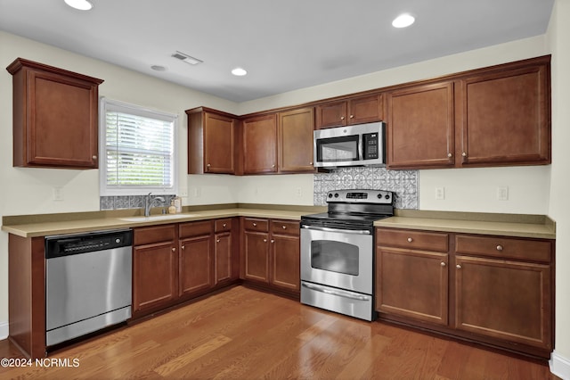 kitchen with light countertops, visible vents, appliances with stainless steel finishes, light wood-style floors, and a sink