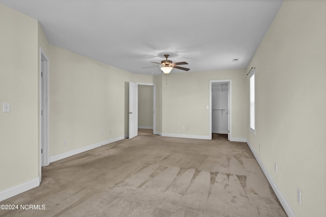 unfurnished room featuring light carpet, ceiling fan, and baseboards