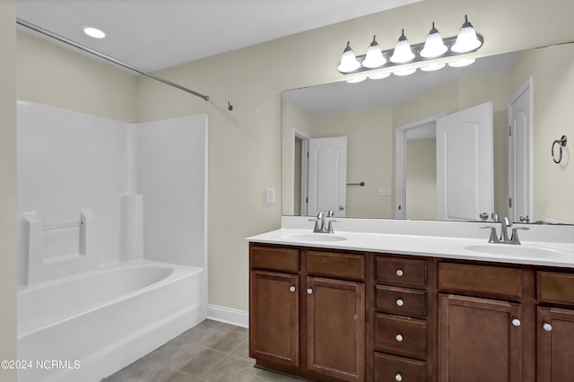 bathroom with double vanity, tile patterned flooring, a sink, and shower / tub combination