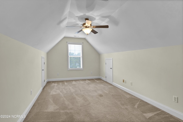 bonus room featuring lofted ceiling, ceiling fan, baseboards, and light colored carpet