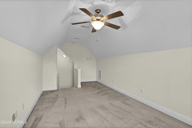 additional living space with lofted ceiling, baseboards, light carpet, and visible vents