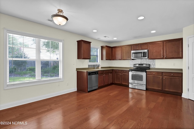 kitchen featuring dark wood-style flooring, recessed lighting, appliances with stainless steel finishes, a sink, and baseboards