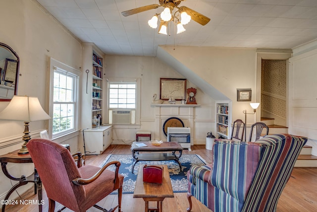 living room with cooling unit, ceiling fan, and light wood-type flooring