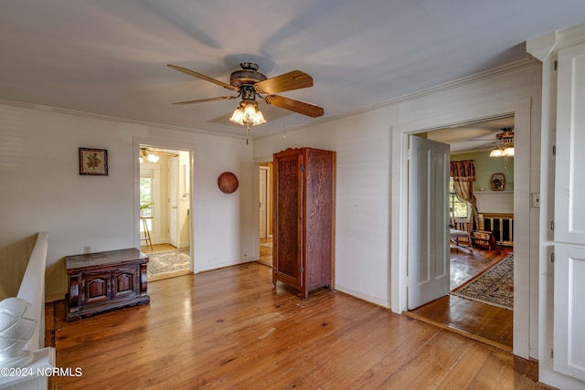 spare room featuring light hardwood / wood-style flooring, ornamental molding, and ceiling fan