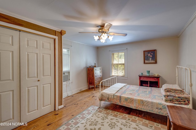 bedroom with crown molding, ceiling fan, light hardwood / wood-style floors, and a closet