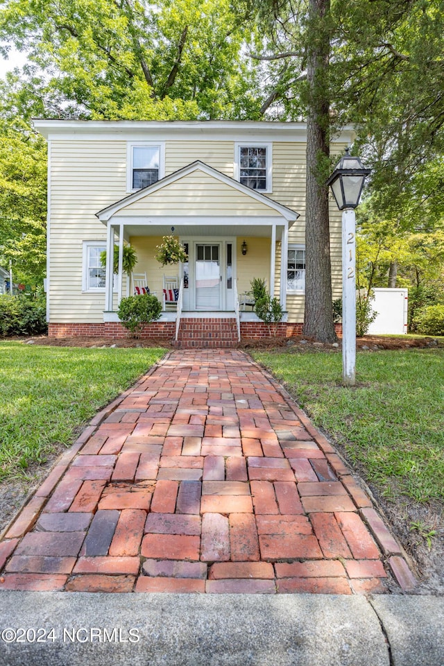 front of property featuring a front yard and covered porch