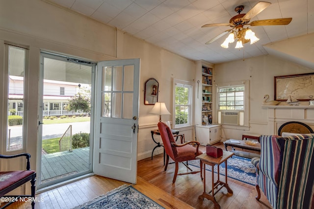 sitting room featuring ceiling fan, built in features, and light hardwood / wood-style flooring