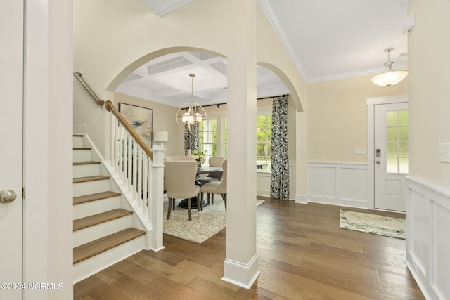 entryway with coffered ceiling, an inviting chandelier, ornamental molding, dark hardwood / wood-style floors, and beamed ceiling