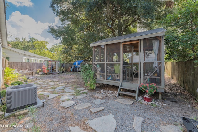 exterior space featuring a fenced backyard, cooling unit, and an outbuilding