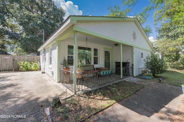 rear view of house featuring covered porch