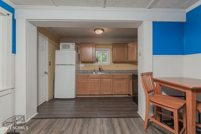 kitchen with crown molding, dark hardwood / wood-style floors, sink, and white appliances