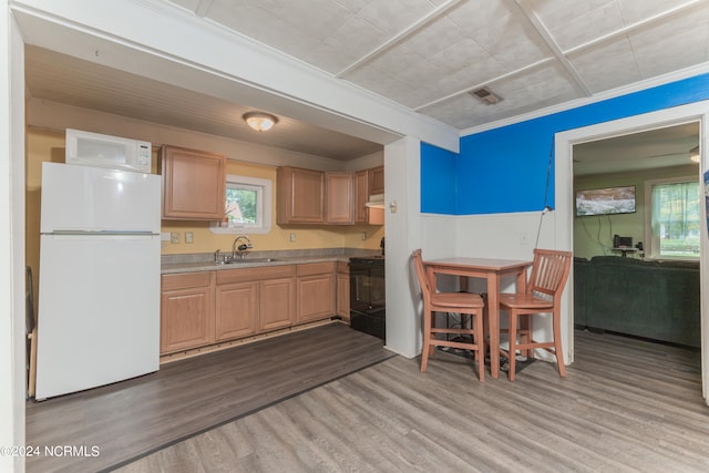 kitchen featuring crown molding, white appliances, sink, wood-type flooring, and light brown cabinets