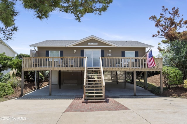 coastal home with a carport, driveway, and stairs