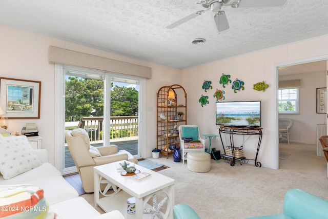 living room featuring a textured ceiling, ceiling fan, and carpet flooring