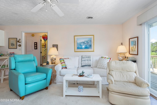 living room featuring light carpet, a textured ceiling, a healthy amount of sunlight, and ceiling fan