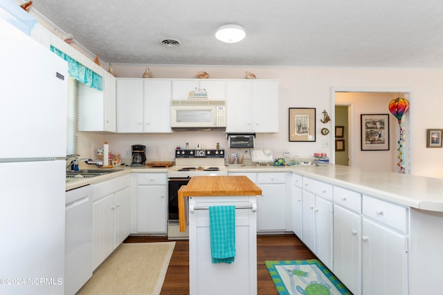 kitchen with white appliances, a textured ceiling, a kitchen island, sink, and dark wood-type flooring