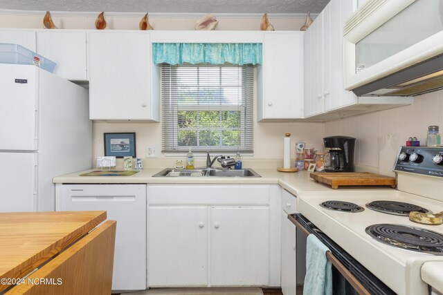 kitchen with white cabinets, white appliances, a textured ceiling, and sink