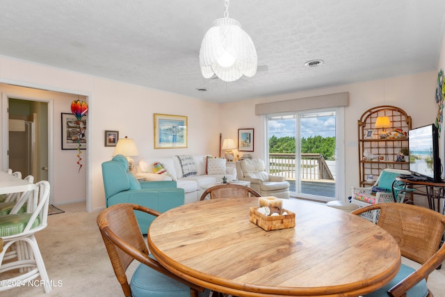 carpeted dining area featuring a textured ceiling