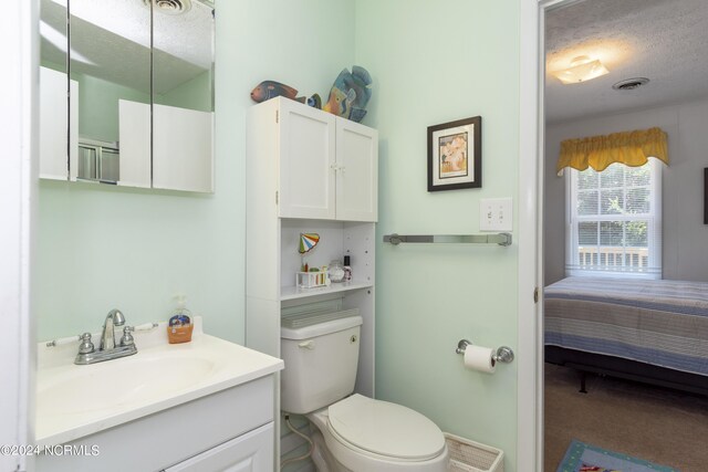 bathroom featuring vanity, toilet, and a textured ceiling