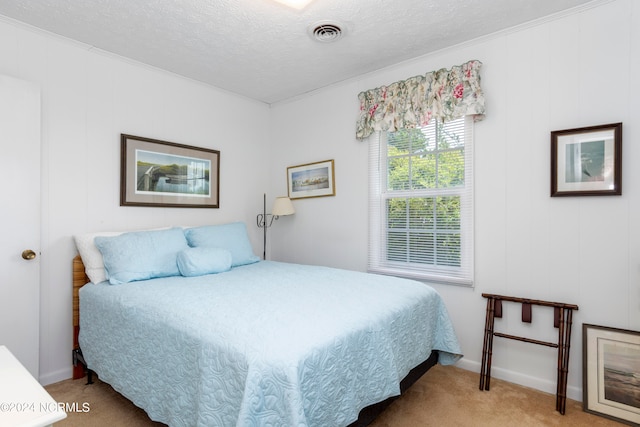 bedroom with light colored carpet and a textured ceiling