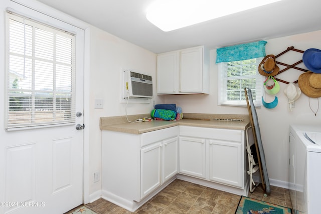 clothes washing area with a wall mounted AC, cabinets, and light tile patterned floors