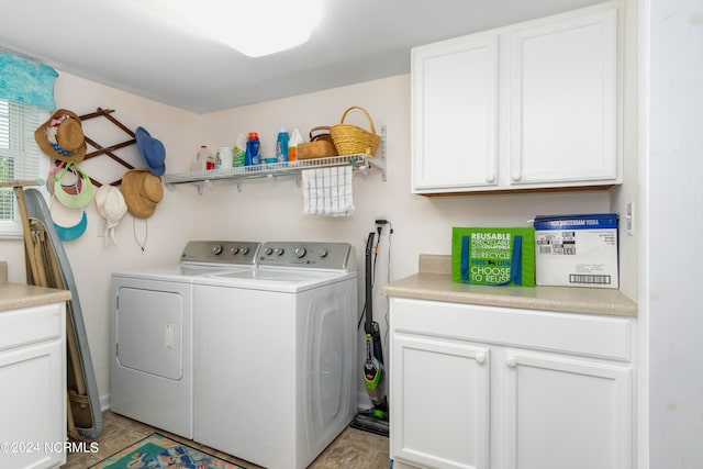 laundry area featuring washing machine and dryer, cabinets, and light tile patterned floors