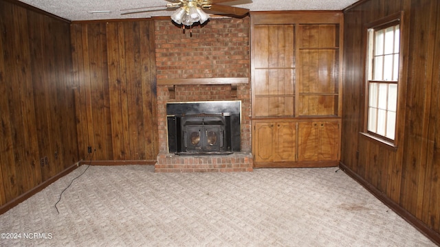 unfurnished living room featuring ceiling fan, light carpet, a textured ceiling, and wooden walls