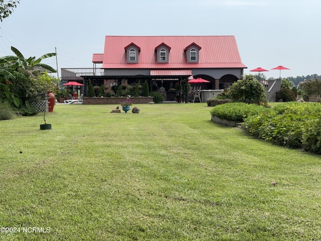 exterior space with metal roof and a front lawn