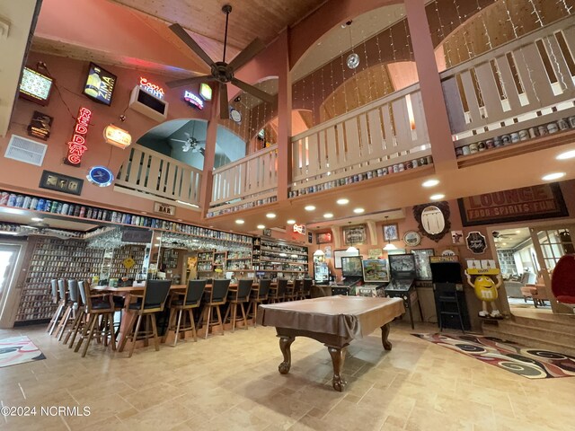 game room featuring billiards, high vaulted ceiling, light tile patterned flooring, and bar area