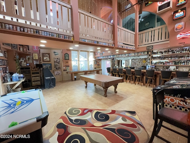 recreation room featuring a towering ceiling, billiards, and wet bar