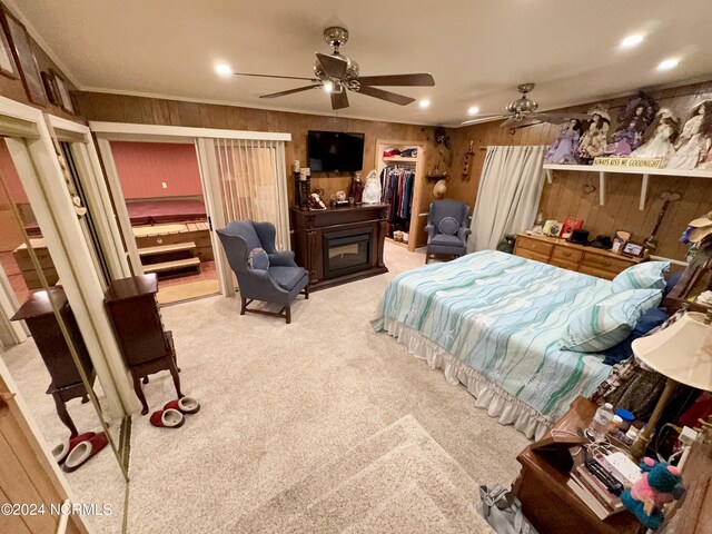 bedroom with carpet, wooden walls, a closet, and ceiling fan