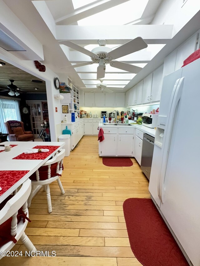 kitchen with white appliances, ceiling fan, white cabinetry, and light wood-type flooring