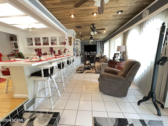 living area featuring light tile patterned floors, wooden ceiling, and a ceiling fan