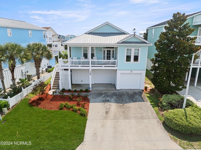 raised beach house featuring a porch and a garage