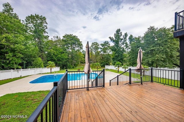 view of swimming pool with a wooden deck and a patio area