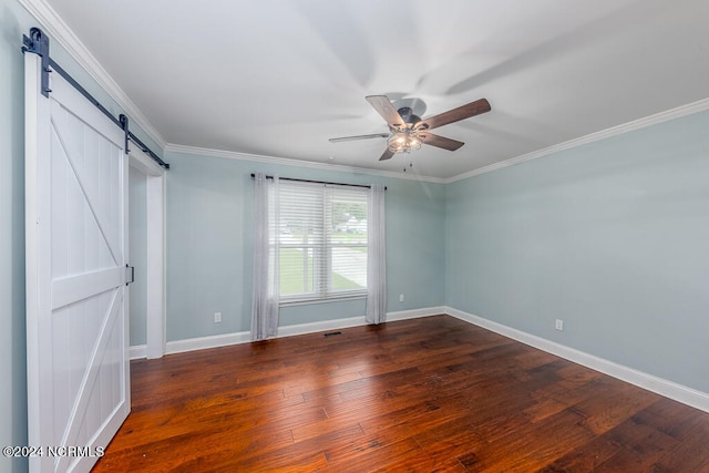 empty room with a barn door, wood-type flooring, crown molding, and ceiling fan