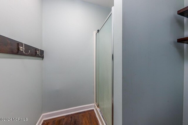 bathroom featuring wood-type flooring and a shower with door