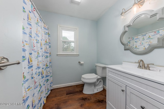 bathroom featuring vanity, wood-type flooring, and toilet