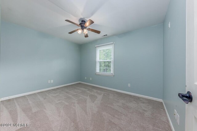 carpeted spare room with ceiling fan