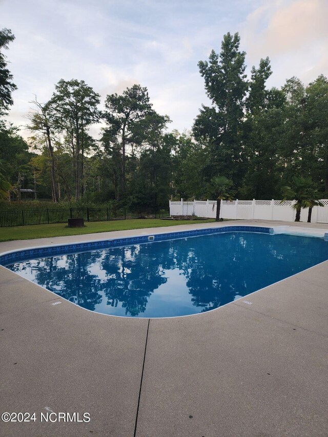 view of pool featuring a lawn